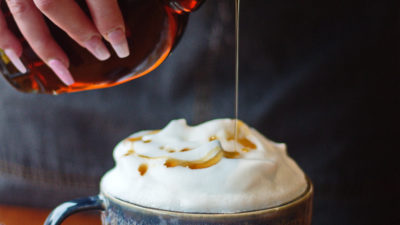 latte with foam topped with maple syrup